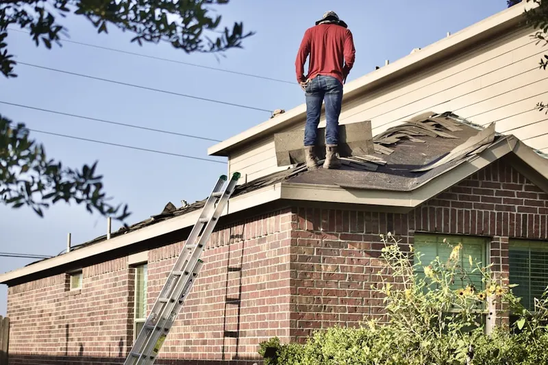 Professional roofer working on a residential roof in Roma